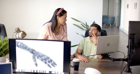 Colleagues Collaborating on Robotics Project in Modern Office