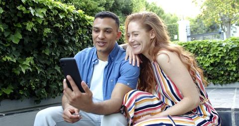 Couple Sharing Happy News Via Video Call on Front Steps