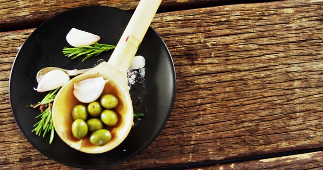 Rustic Wooden Table with Fresh Garlic, Olives and Herbs on Black Plate - Download Free Stock Images Pikwizard.com