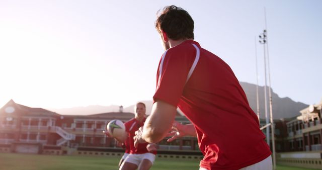 Rugby Players Passing Ball on Field During Sunset Practice - Download Free Stock Images Pikwizard.com