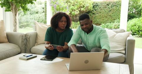 African american couple analyzing finances on laptop at home