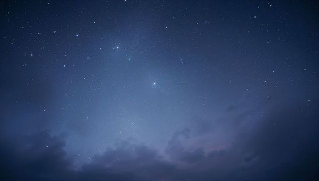 Star-filled Night Sky Over Low Clouds with Deep Blue Gradient and Bright Stars