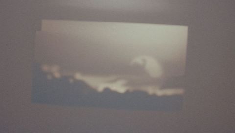 Projecting moody blurred seascape silhouette onto interior wall with rectangular halo