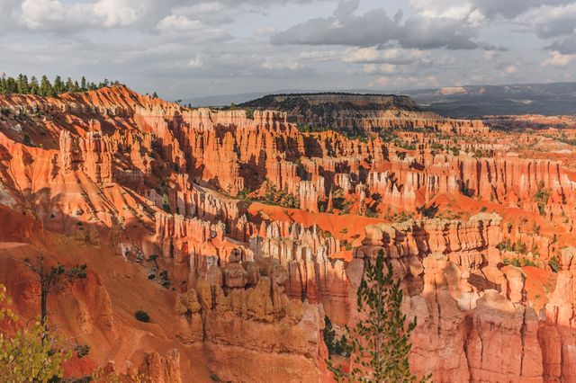 Spectacular view of Bryce Canyon highlighting unique hoodoo rock formations under a dramatic sky. Perfect for promoting travel destinations, nature conservation, outdoor adventures, and geological studies.