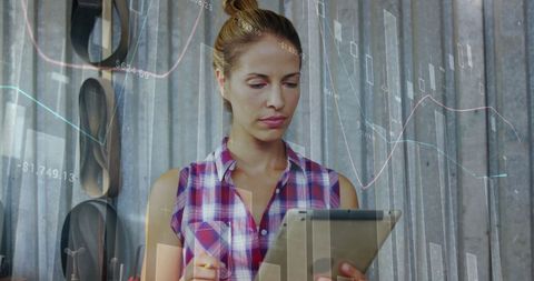 Businesswoman Analyzing Financial Data Using Tablet in Office