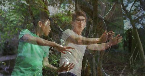 Father and son practicing tai chi under forest canopy with ethereal double exposure