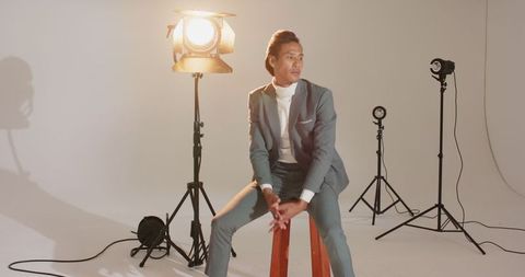 Asian Male Model in Grey Suit Posing in Studio with Dramatic Lighting