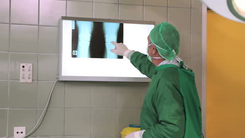 Surgeon Analyzing X-Ray Image on Lightbox in Operating Room