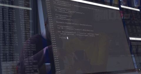Reviewing Code on Monitor with Tablet Reflection, Team Collaborating in Office