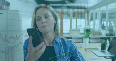 Businesswoman Engaging with Financial Data on Smartphone in Modern Office