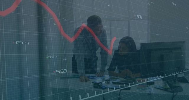Colleagues analyzing financial charts on workplace monitors