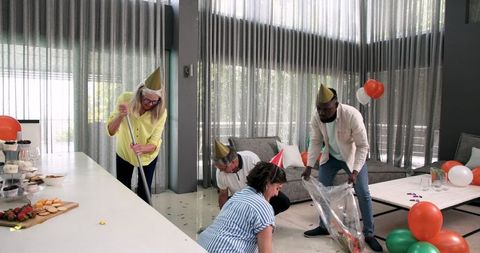 Diverse Team Cleaning Up After Office Party Celebration