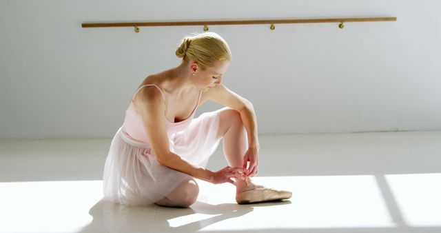 Ballet Dancer Adjusting Pointe Shoes in Sunlit Studio - Download Free Stock Photos Pikwizard.com