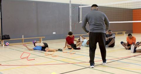 Male volleyball team training with african american coach on indoor court