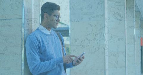 Young Man With Smartphone Amidst Scientific Formulae Background