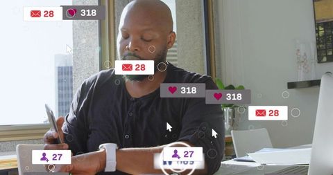 Checking smartwatch while holding smartphone at office desk with social notifications overlay