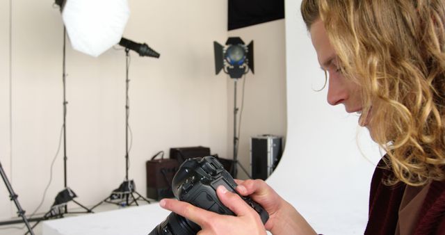 Photographer Reviewing Images in Studio with Professional Equipment - Download Free Stock Images Pikwizard.com