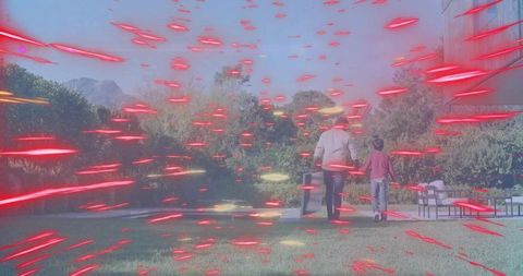 Parent and child walking across lawn pulling luggage through futuristic red-light streaks