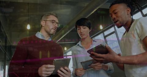 Diverse Business Team Analyzing Financial Data on Tablets