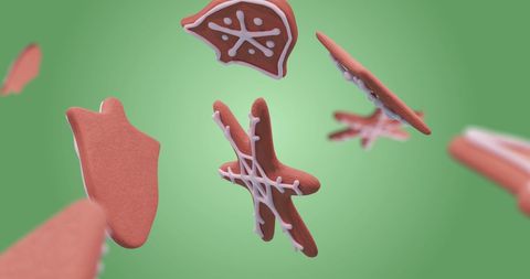 Gingerbread cookies falling against green backdrop