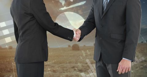 Business partnership handshake with financial graphs