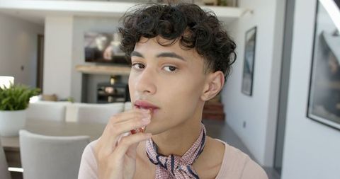 Young Man Applying Lip Balm in Modern Home Interior