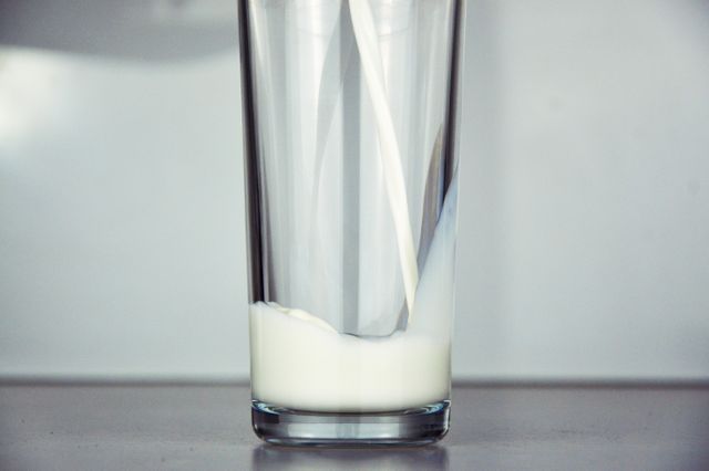 Glass of Milk Being Poured in Close-Up Shot with Minimalist Background - Download Free Stock Photos Pikwizard.com