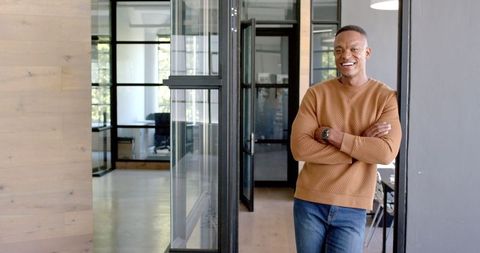 Smiling Businessman Standing Confidently in Modern Office Environment