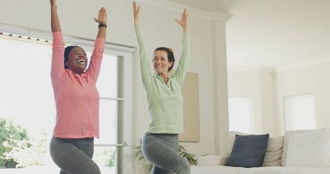 Diverse Friends Practicing Yoga at Home in Living Room
