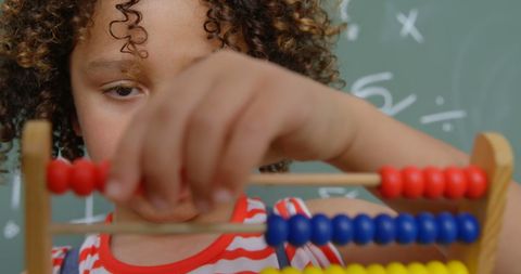 Curly-haired Boy Using Abacus in Classroom with Focus and Concentration - Download Free Stock Images Pikwizard.com