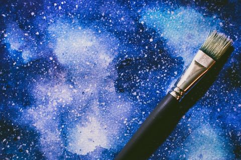 Vibrant blue starry sky acrylic painting with brush