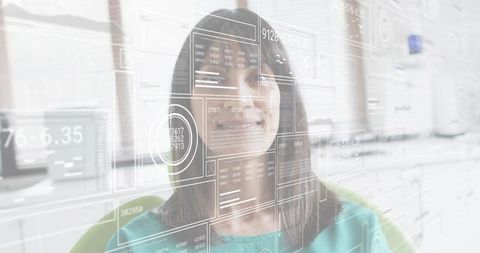 Mature professional woman navigating holographic ar data dashboard in modern office