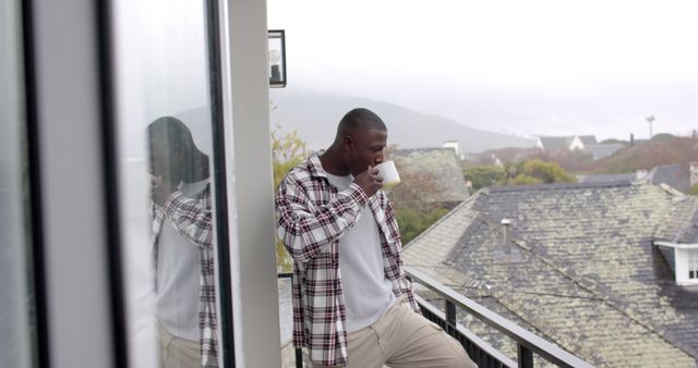 Man Enjoying Morning Coffee on Balcony Overlooking Scenic Town - Download Free Stock Images Pikwizard.com