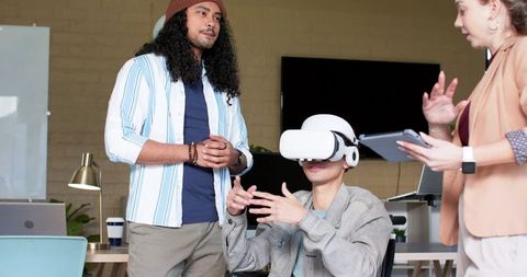 Diverse coworkers testing vr headset in modern office collaboration and user experience demo