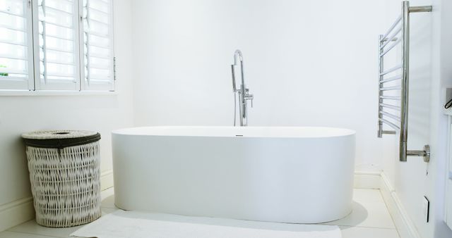 A modern bathroom features a sleek freestanding bathtub, with copy space. The bright interior and clean lines convey a sense of luxury and relaxation.