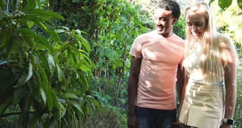 Diverse Couple Exploring Lush Garden with Smartwatch on Display