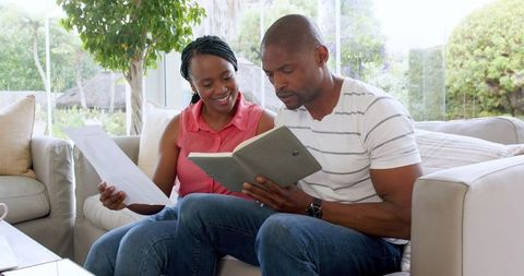 Couple reviewing documents together in living room