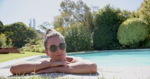 Woman Sunbathing by Pool on a Sunny Day