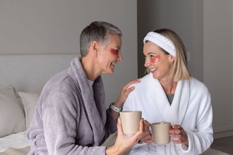 Mother and daughter sharing cozy at-home spa morning with robes and under-eye patches