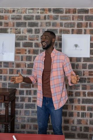 Smiling man by rustic brick wall ensuring warm welcome