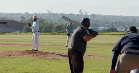Local Baseball Pitcher Winding Up Facing Batter on Community Diamond Field