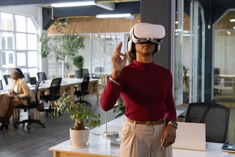 Indian woman using vr headset in modern coworking office exploring virtual collaboration