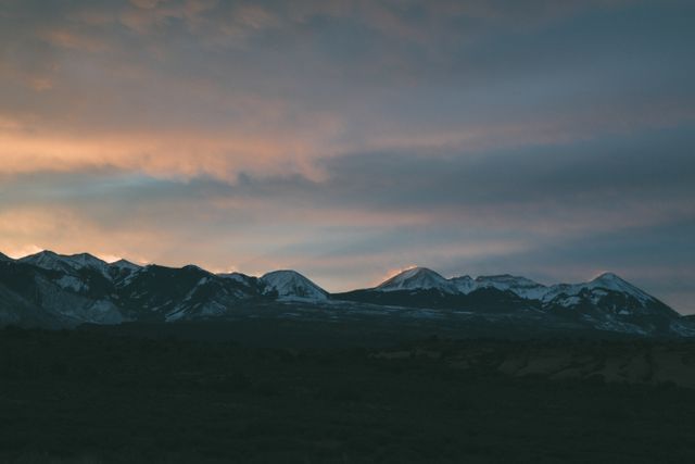 Snowy mountain range under pastel sunset sky - Download Free Stock Photos Pikwizard.com