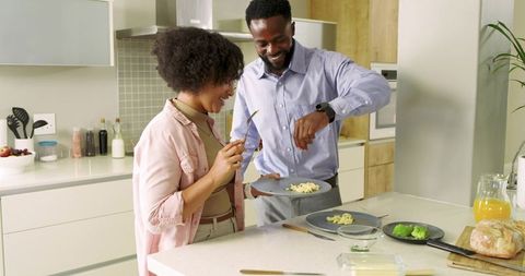 Couple Preparing and Plating Homemade Breakfast on Modern Kitchen Island, Sharing Moment