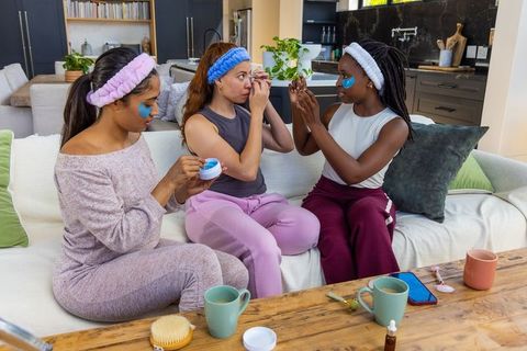 Friends enjoying at-home spa night wearing under-eye patches and cozy loungewear