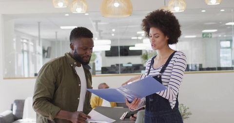 Two Colleagues Reviewing Documents in Modern Office Space