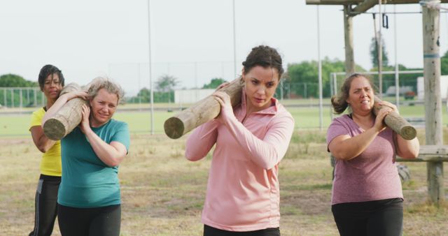 Determined diverse female friends carrying logs on course at bootcamp training - Download Free Stock Photos Pikwizard.com