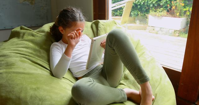 Child Relaxing on Beanbag with Tablet During Indoor Leisure - Download Free Stock Images Pikwizard.com