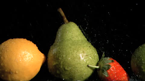 Fresh Mixed Fruits Under Splashes of Water on Black Background