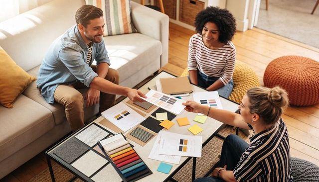 Collaborative interior design team choosing color palette and fabric swatches at home